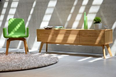 Dweller Sideboard von Jan Kurtz aus hellem Holz, mit Deko-Elementen und grünem Stuhl.